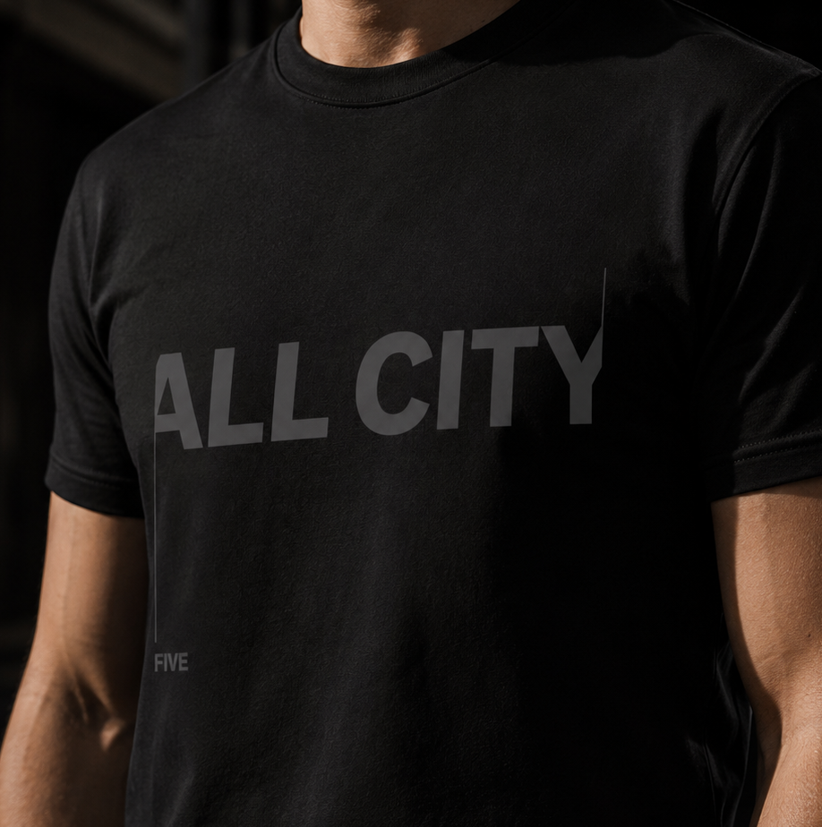 Close-up of the charcoal ALL CITY print on the black tee