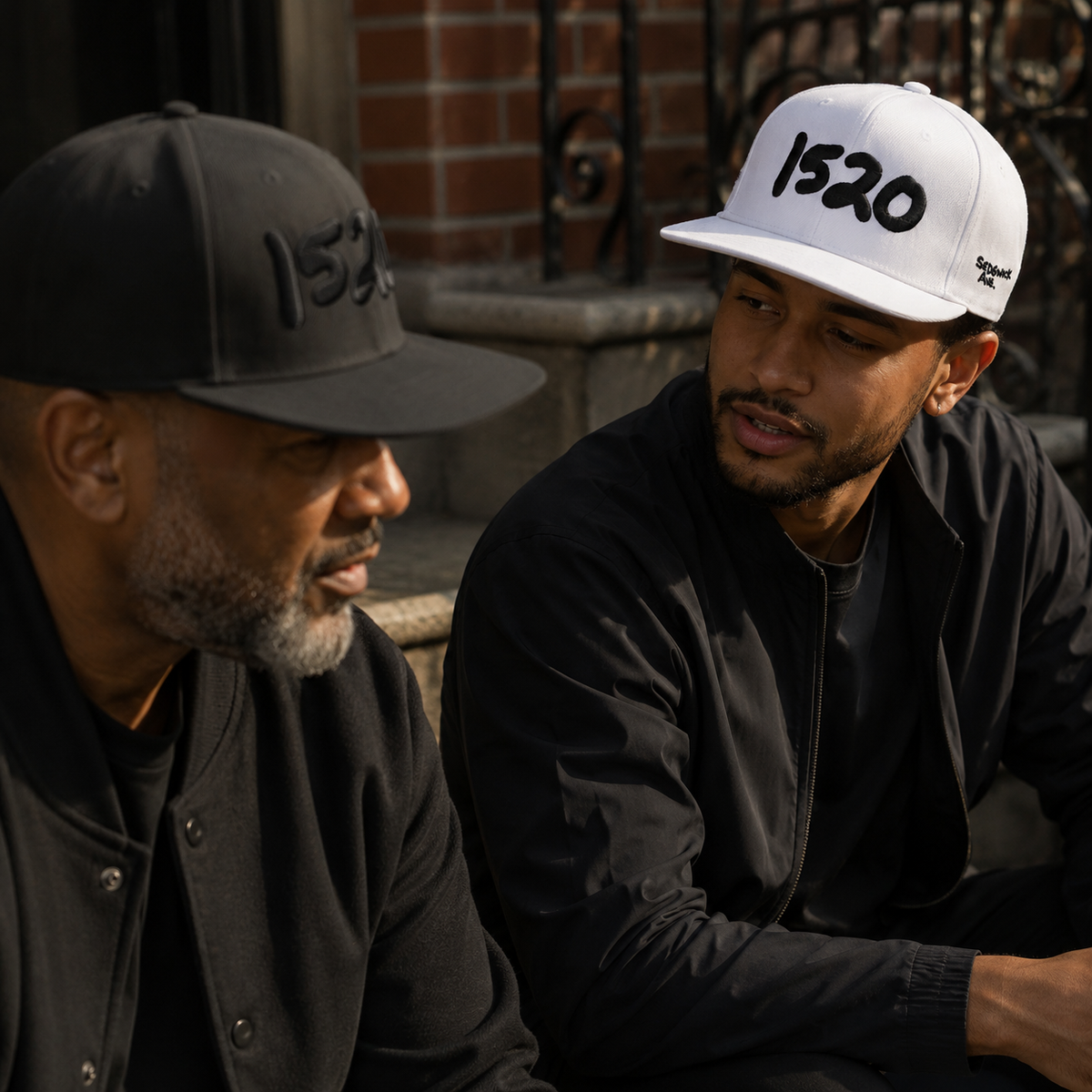 Two men talking, one wearing the black 1520 Cap and one the white
