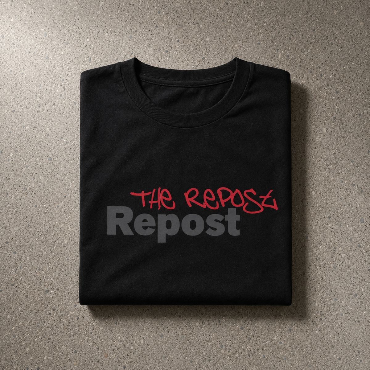 Folded black Repost Tee showing THE REPOST handstyle over charcoal Repost